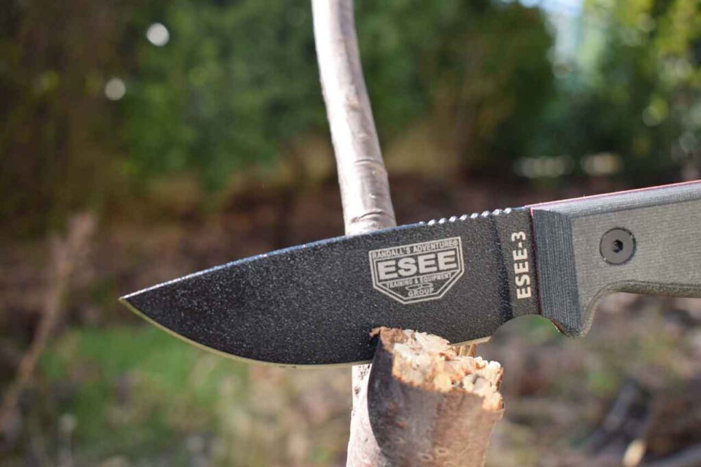 ESEE 3 Knife With 1095 Steel Blade embedded in a tree stump