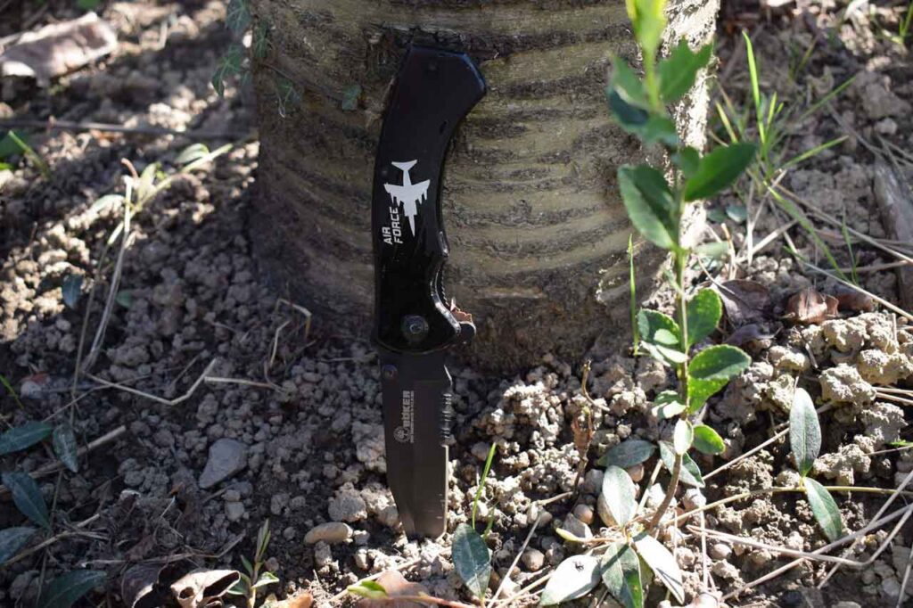 Bocker Folding Knife Stuck in The Ground on a sunny day