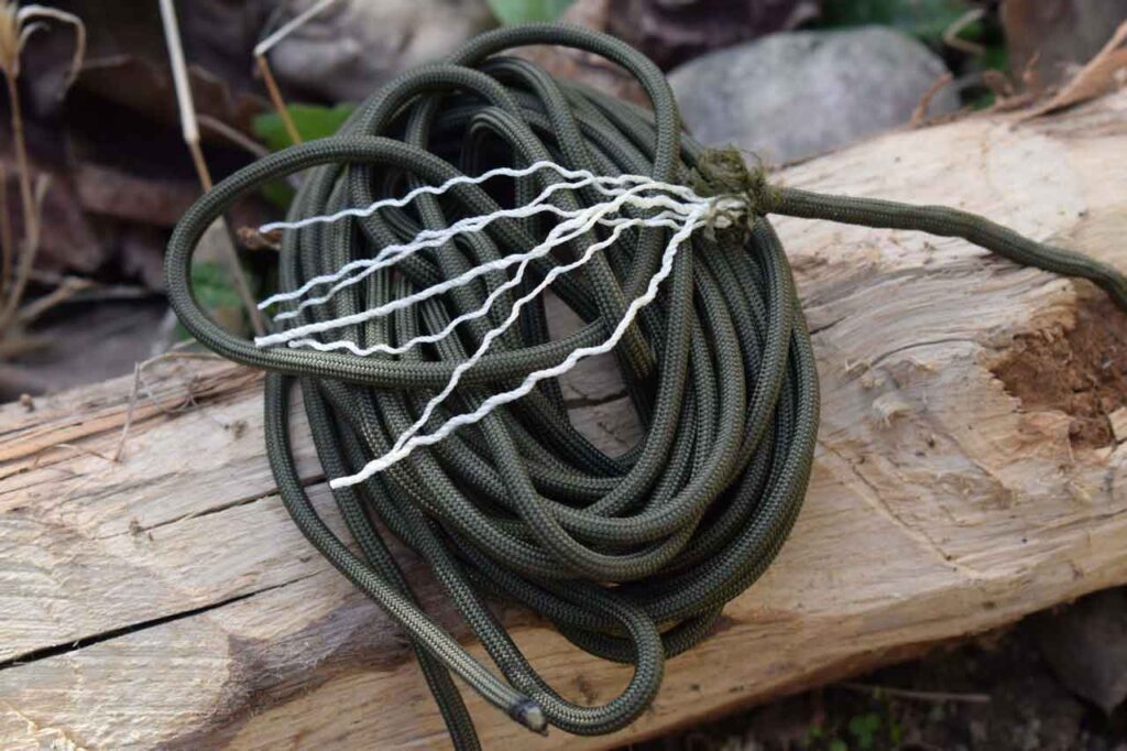 550 seven strand paracord with seven inner strands displayed layed on a log