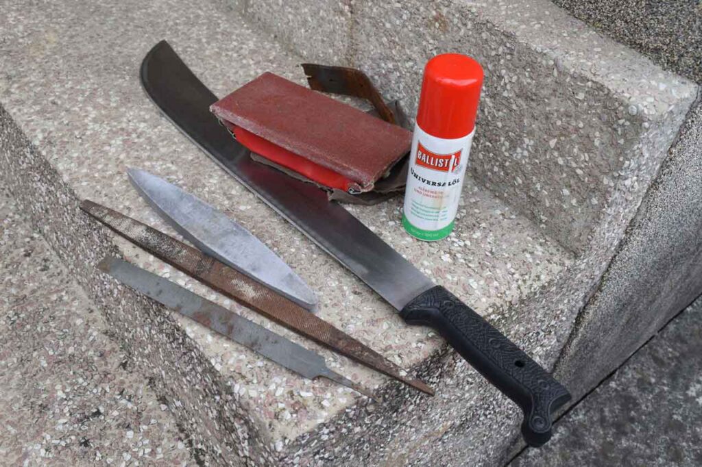 A machete and some sharpening tools arranged on the porch stairs