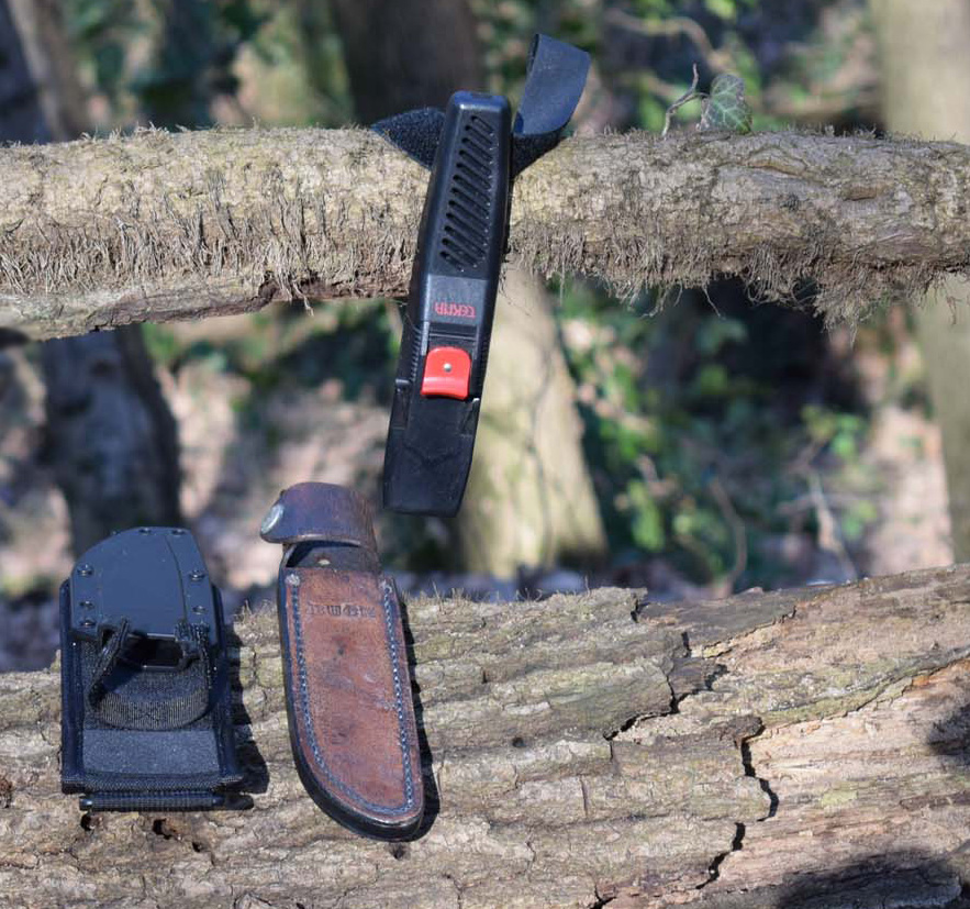 Knife Sheaths, polymer, leather and plastic placed on fallen tree