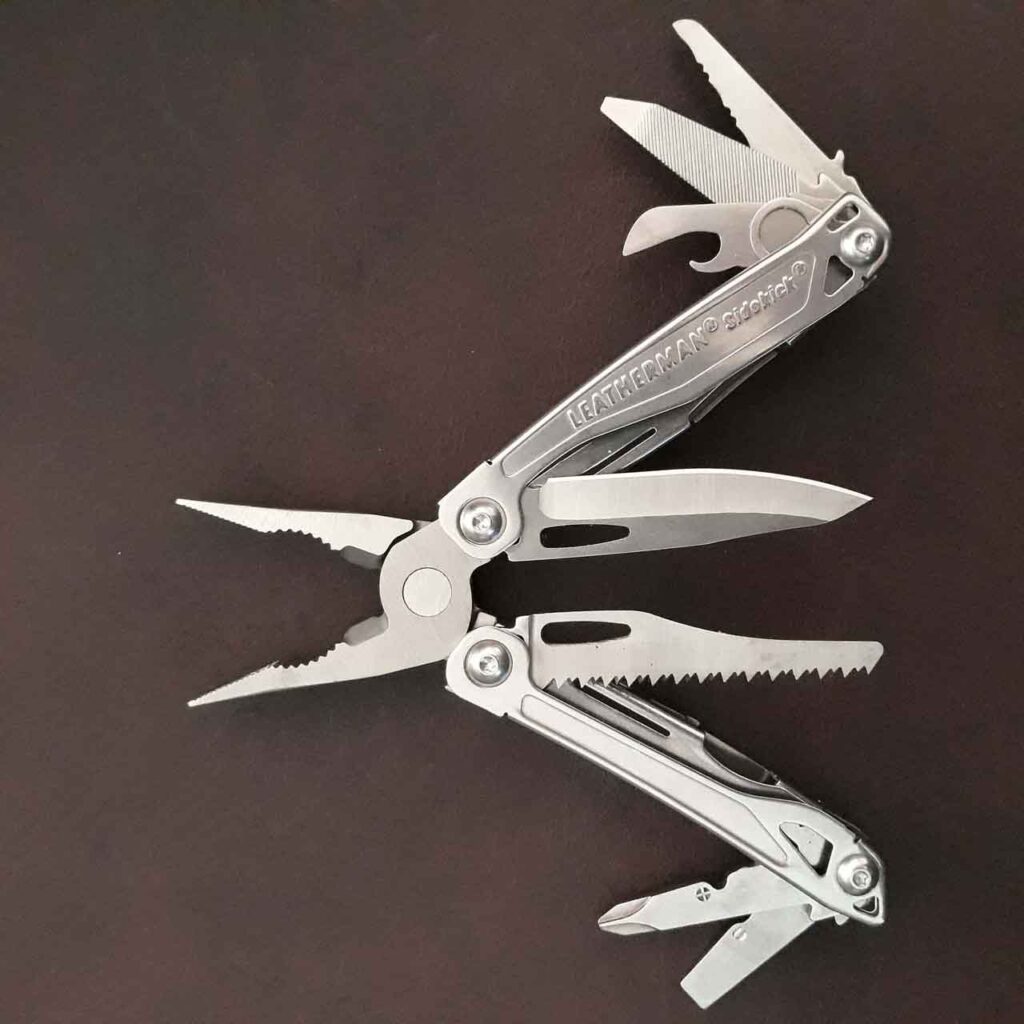 Leatherman Sidekick opened to show the best survival multi-tools to display all the tools on a dark brown leather background