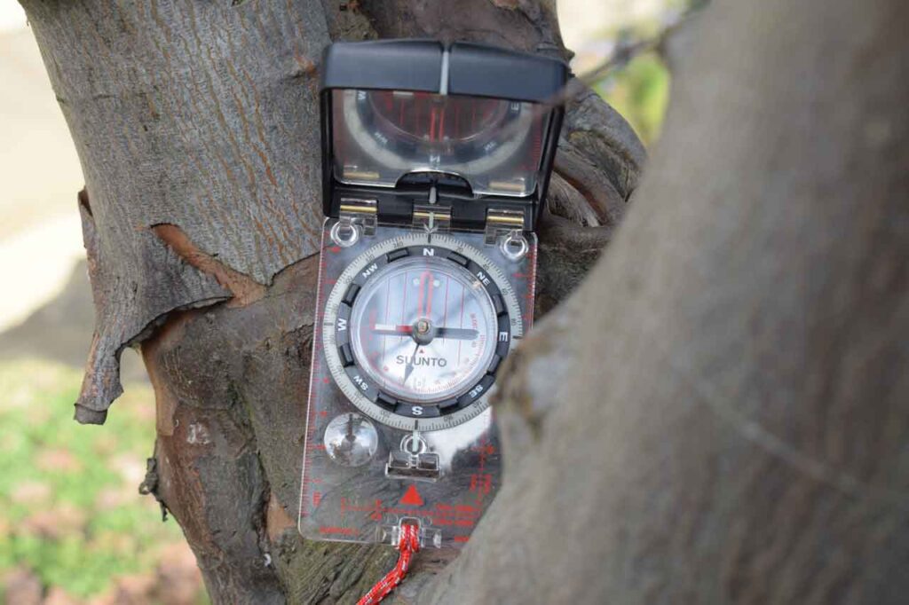 A Suunto MC2 Compass Wedged On A Tree